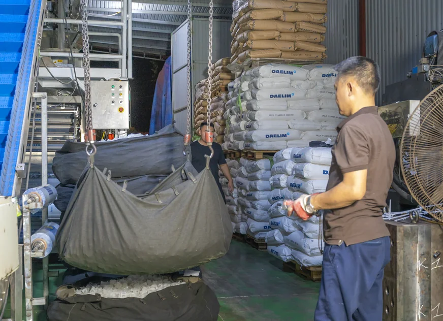 Công nhân Kiên Phú đóng bao thành phẩm tại khu vực kho, hàng xếp theo lô phía sau